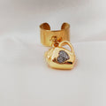 Gold-tone mug charm ring with a sparkling heart worn on a hand.