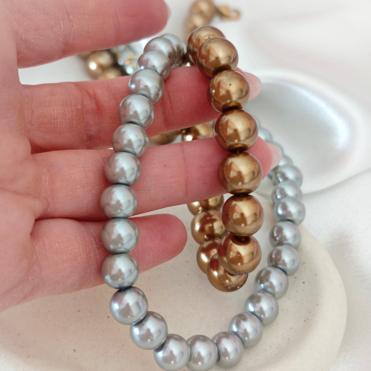 Close-up of Lustre necklace beads in silver and bronze tones