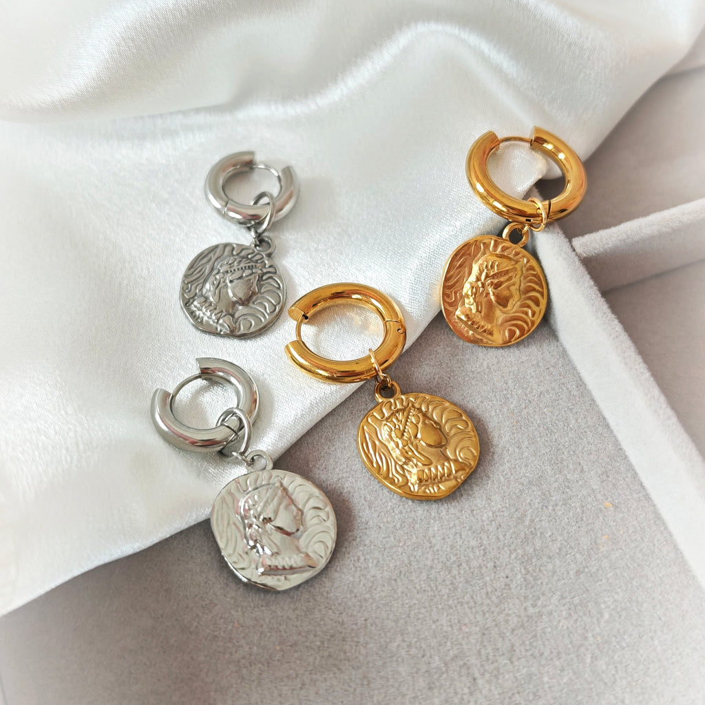 Gold-tone and silver-tone chunky hoop earrings with embossed coin charms