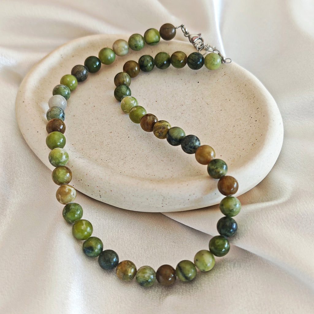 Olive Agate necklace with round olive green and brown agate beads on an ivory display.