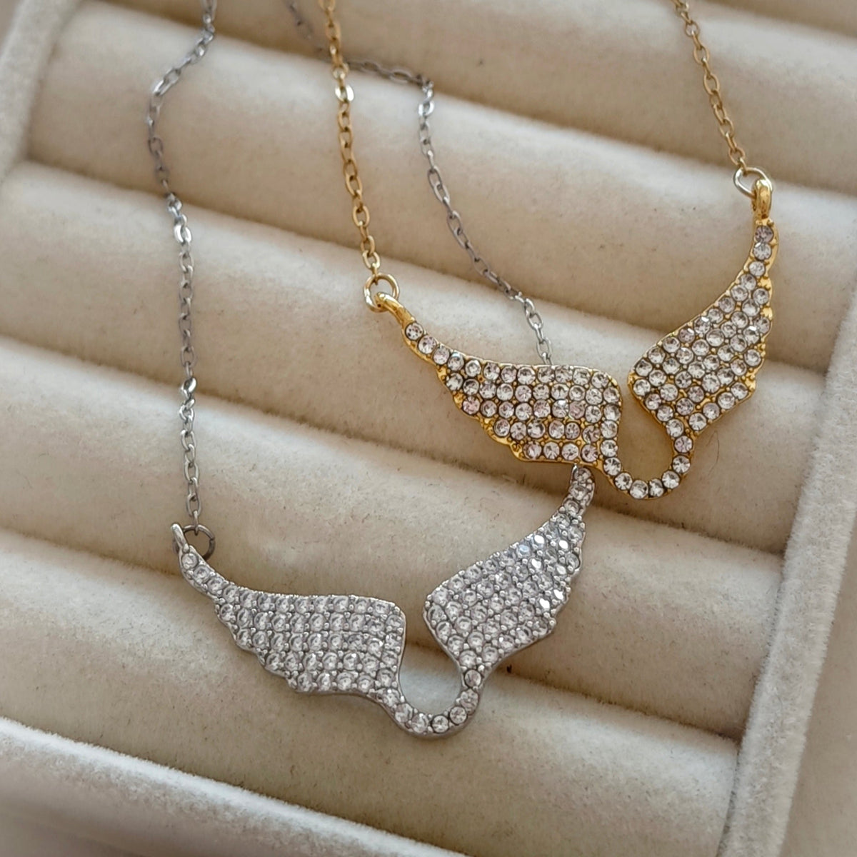 Close-up of gold and silver crystal wing pendants