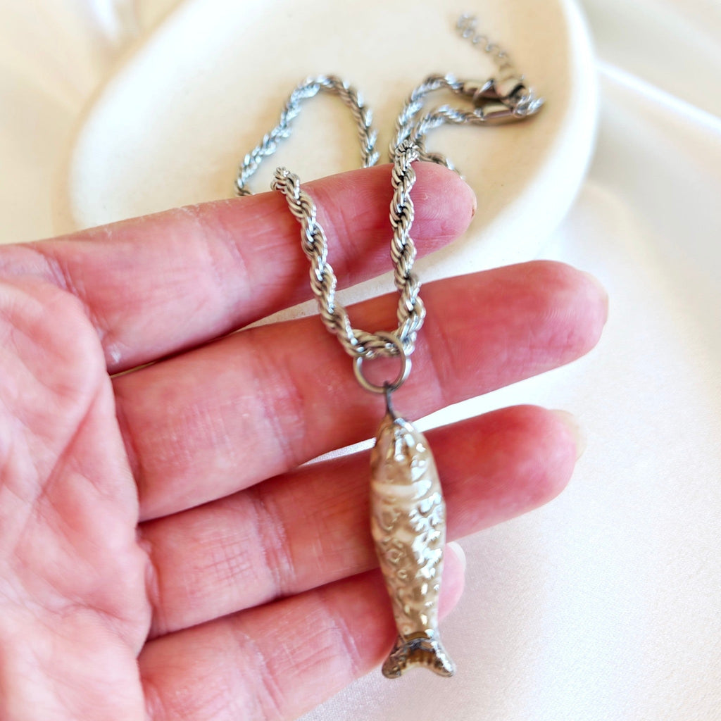 Close up of fish pendant stainless steel necklace