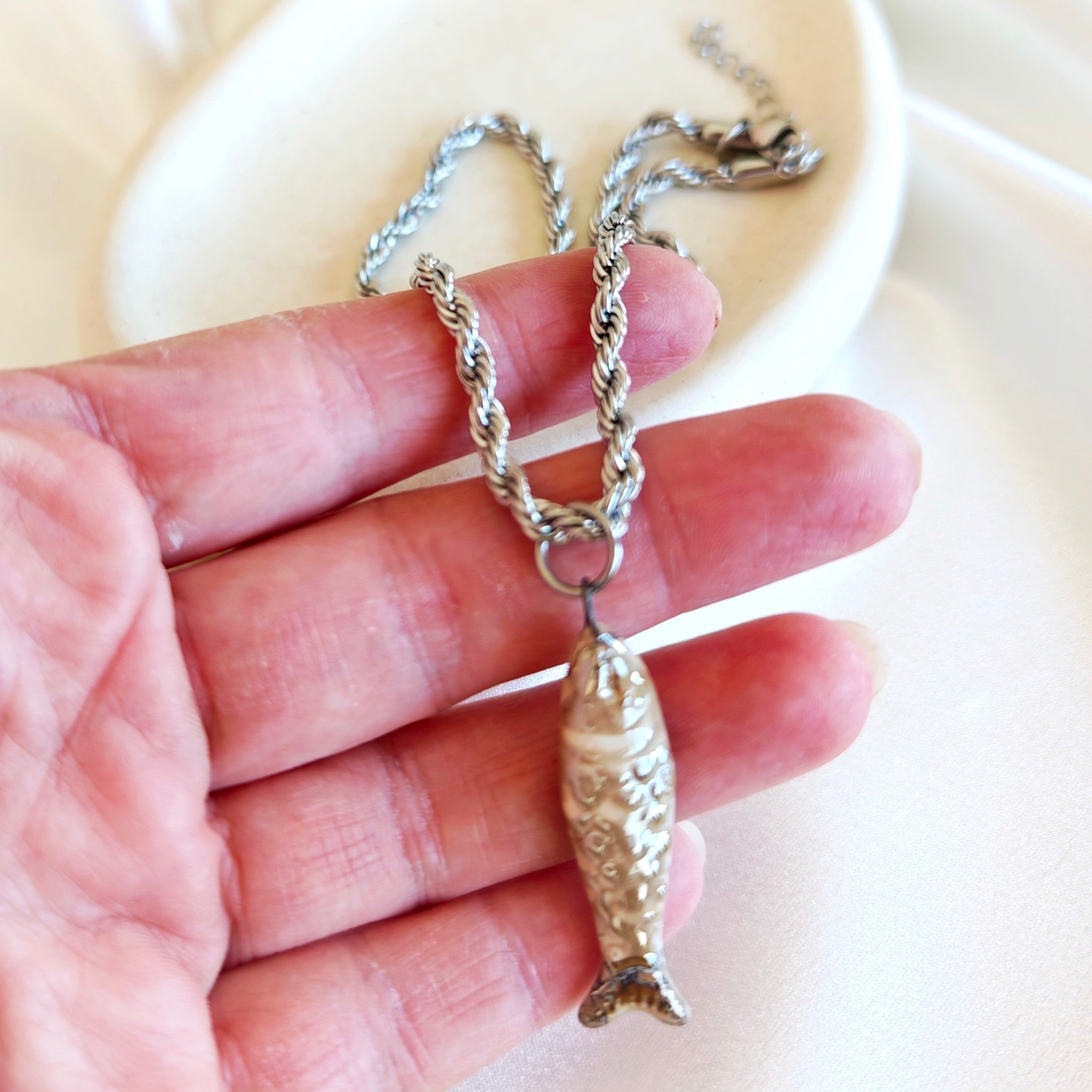 Close up of fish pendant stainless steel necklace