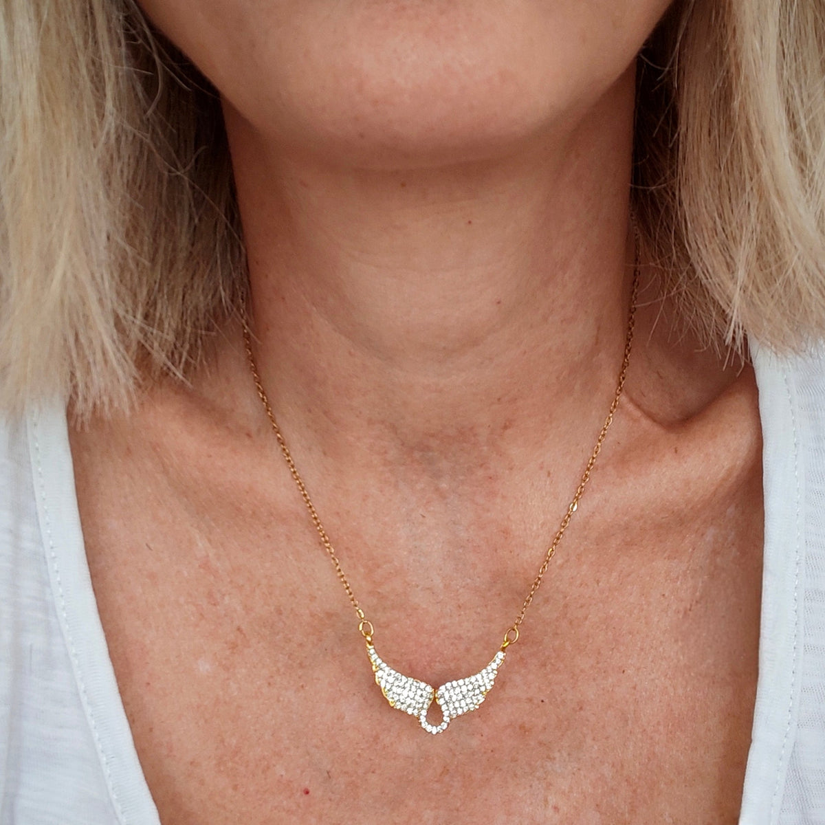 Gold wings necklace with crystals worn on neck