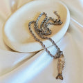Fish pendant stainless steel rope necklace on ceramic dish