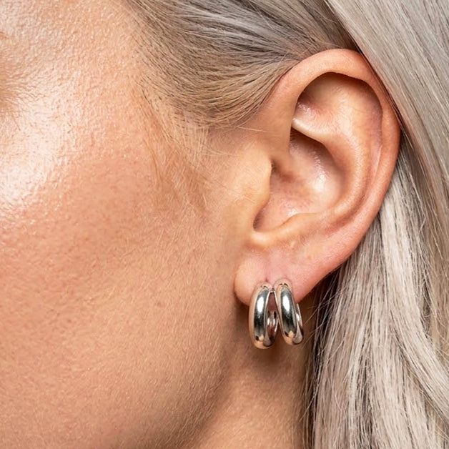 Silver duo hoops worn on the ear, close-up