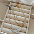 Gold and silver wings necklaces with clasps on jewelry tray