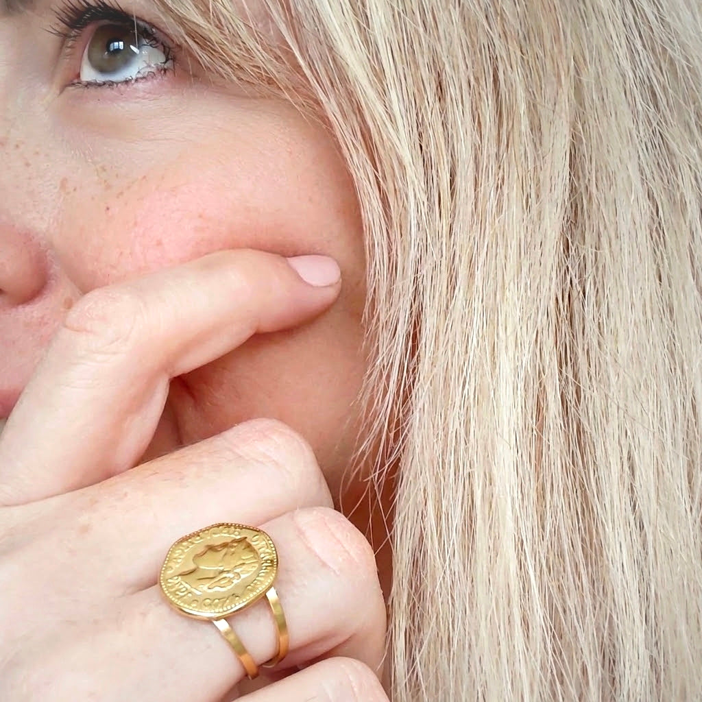 Model wearing gold hexagonal coin ring with double band